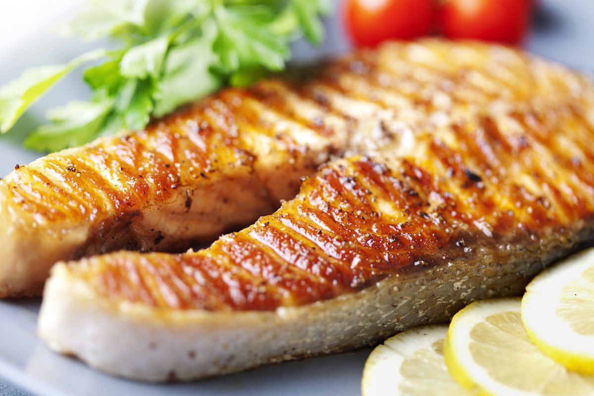 Crispy grilled salmon steak with cherry tomatoes and parsley
